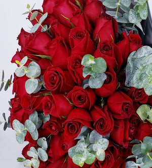 One hundred red roses in a full hand-tied bouquet